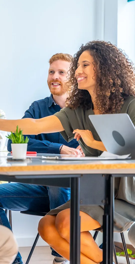 Gruppe junger Menschen sitzt an einem Konferenztisch.