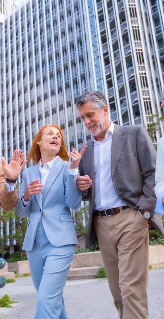 Gruppe Personen unterhält sich beim Gehen. 